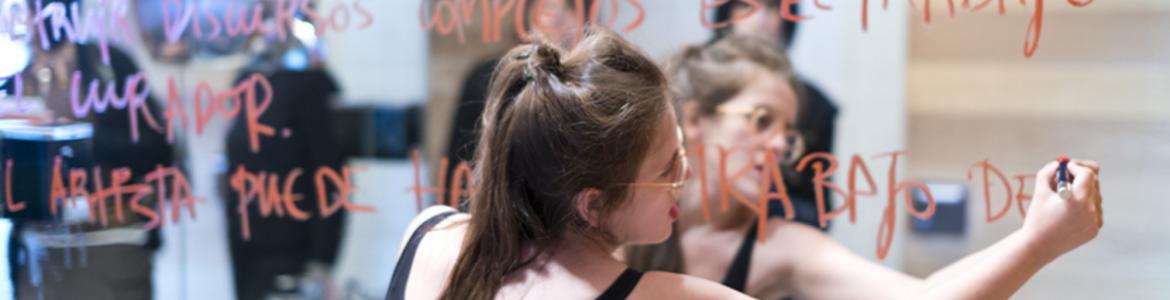 Participante en un taller artístico escribiendo en un espejo