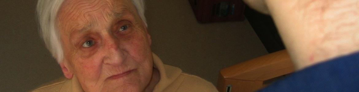 Formación Alzheimer Mujer joven abrochando botón a mujer mayor