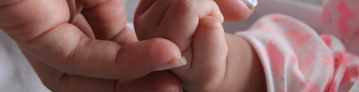 Bebé agarrando dedos de su madre