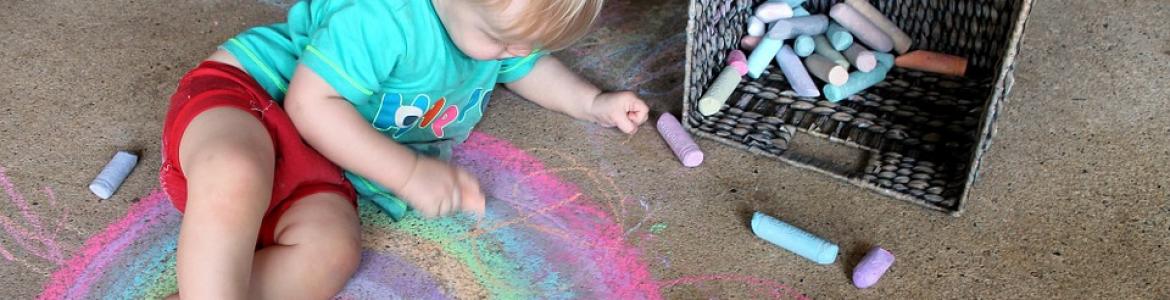 Niño pintando con tizas.