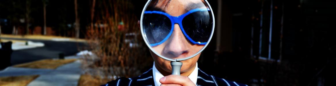Imagen hombre con lupa y gafas azules