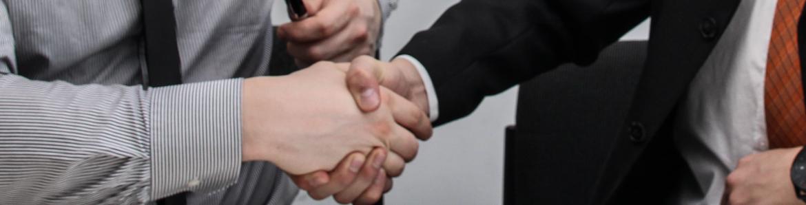 Dos hombres se dan la mano tras la firma de un acuerdo
