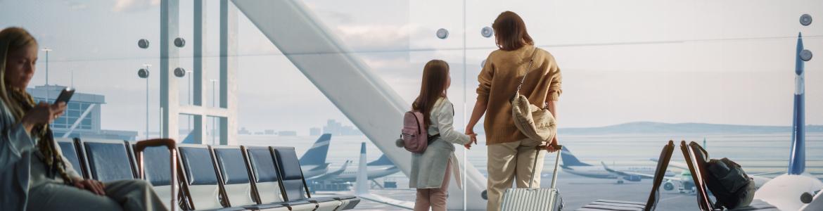 imagen de mujer y niña en aeropuerto con maleta