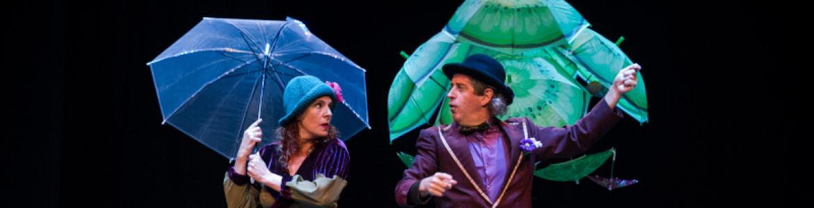 imagen de los dos actores en escena con paraguas abiertos 