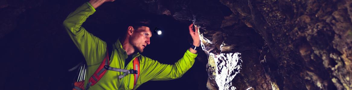 Espeleólogo iluminando una pared de una cueva
