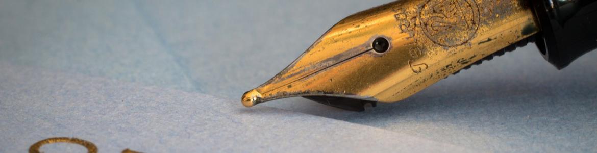 Gold nib of a fountain pen and sheet of paper