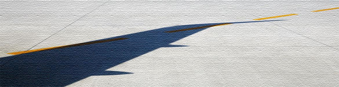 Sombra de un ala de un avión sobre la pista de despegue