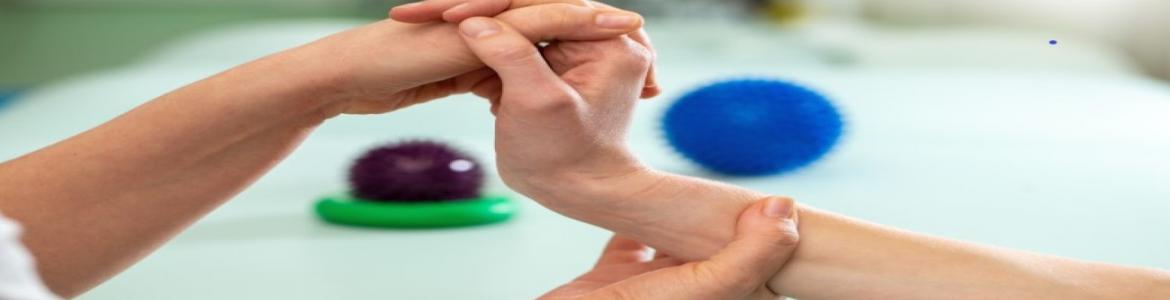 Terapeuta ocupacional movilizando mano de una paciente