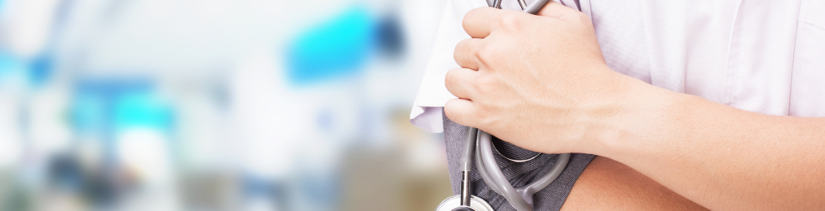 Primer plano a la derecha del torso de un profesional médico con bata blanca con los brazos cruzados y en la mano un fonendoscopio