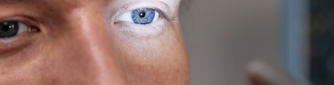 primer plano de un ojo azul con el reflejo de una luz que le enfoca