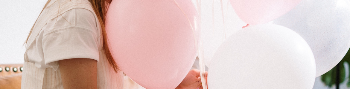 Imagen de persona con globos de color rosa y blanco