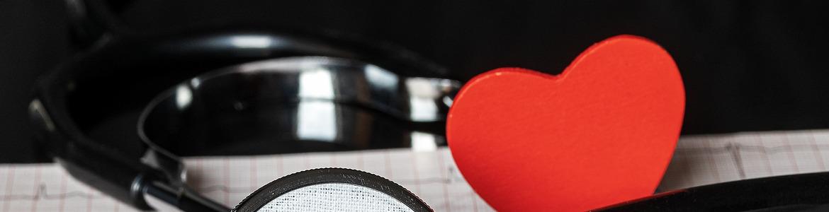 Imagen de un electrocardiograma junto a un fonendoescopio y un corazón