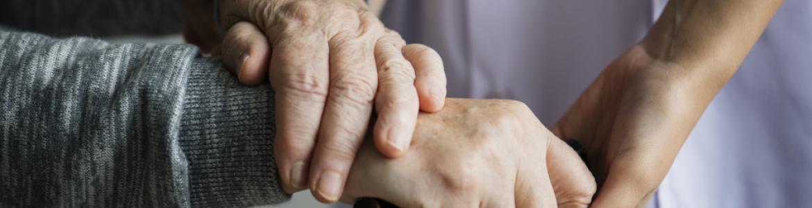 una mujer joven sostiene la mano de otra mayor