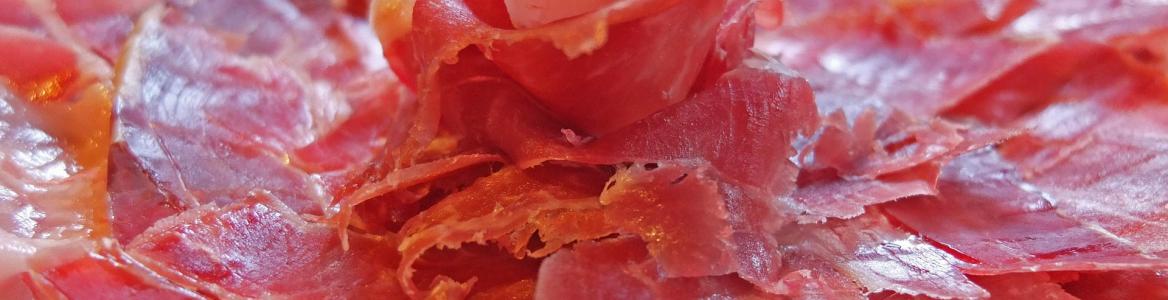 Jamón ibérico cortado en un plato haciendo una pequeña montaña en el centro