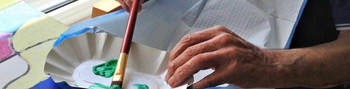 Actividades de dinamización en centros Manos personas mayor pintando con pincel