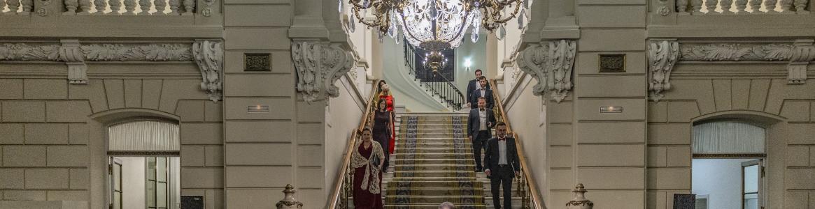 palace staircase down which a group of people are descending
