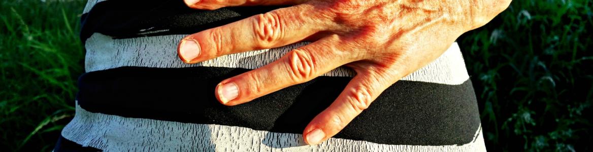 imagen del abdomen de una persona con una mano indicando dolor