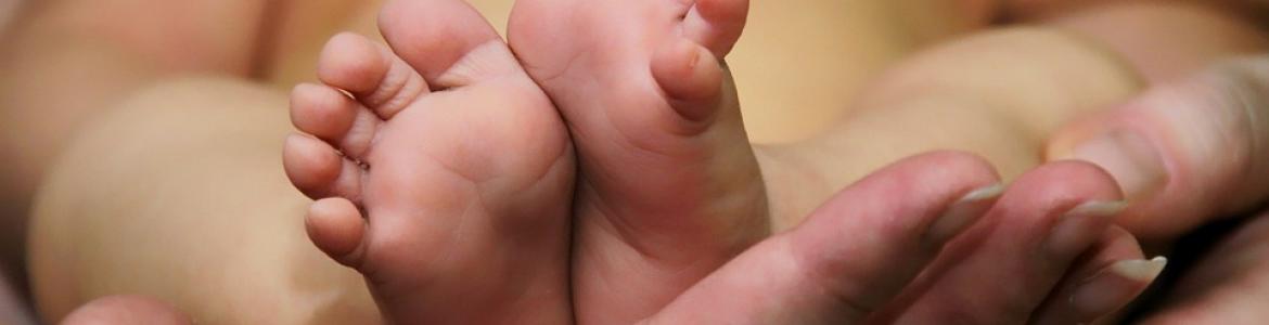 pies de bebé sobre manos de padres