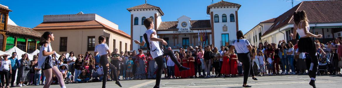 Plaza de pinto con Ayuntamiento y jóvenes bailando