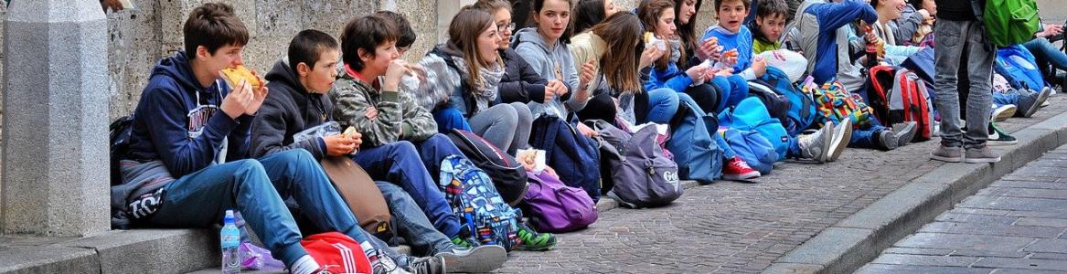 Niños sentados a las puertas de un museo