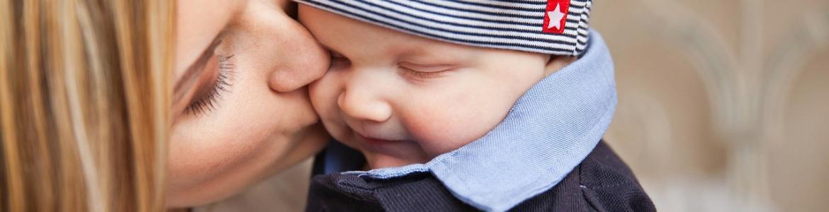 Las caras de una madre besando en la mejilla a su hijo sonriente