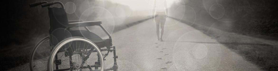 Imagen de silla de ruedas y persona caminando hacia horizonte