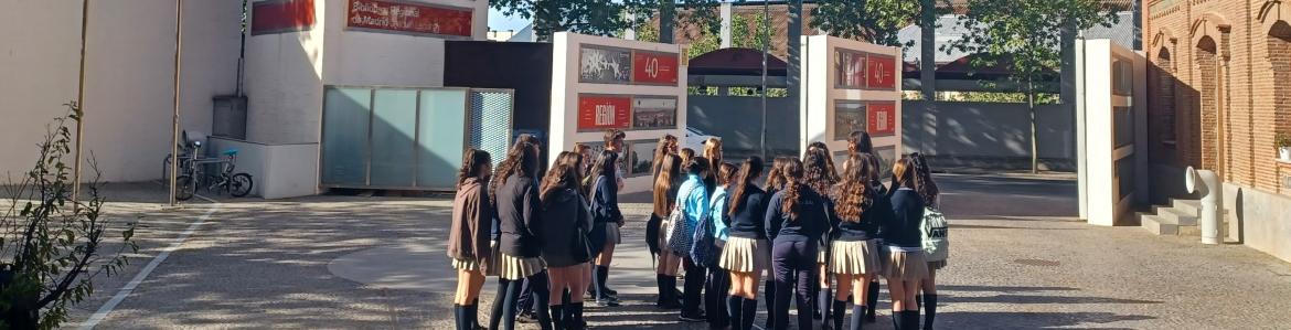 Grupo de estudiantes en círculo en el exterior de un museo