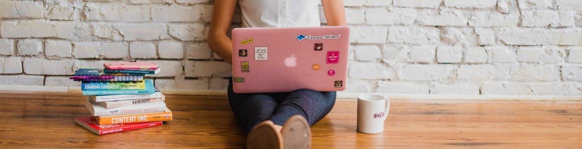 Girl sitting on the floor typing on computer