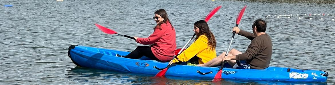 Tres jóvenes remando en una piragua