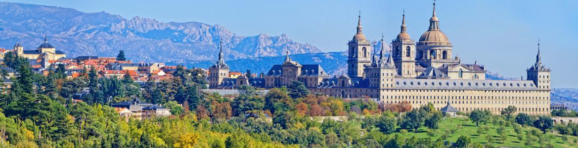 View of the Monastery and municipality of El Escorial with a mountainous landscape in the background