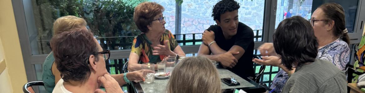 reunión en torno a mesa de gente joven y mayor