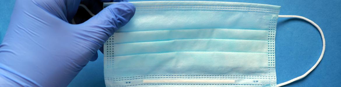 mascarillas guantes material sanitario Una mano con un guante con una mascarilla