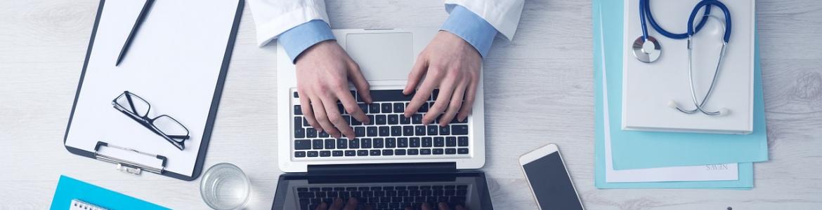 Médico escribiendo en ordenador