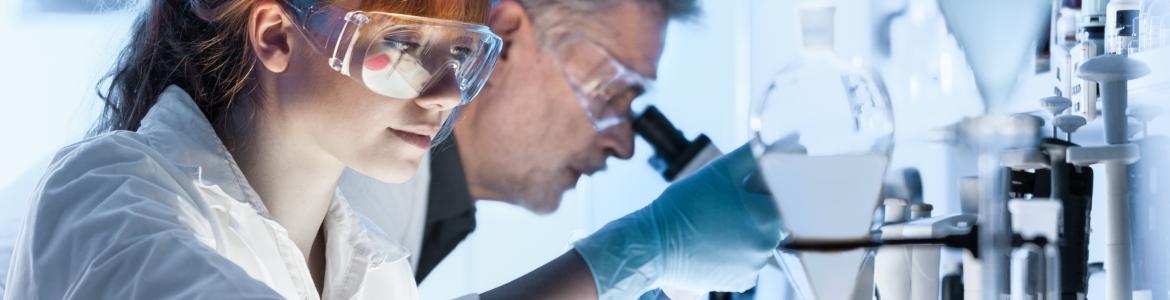 Woman and man scientists working in laboratory with microscope and test material and