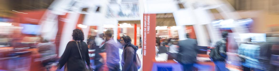 stand eliptico de Feria empleo  de la Comunidad de Madrid con transeuntes