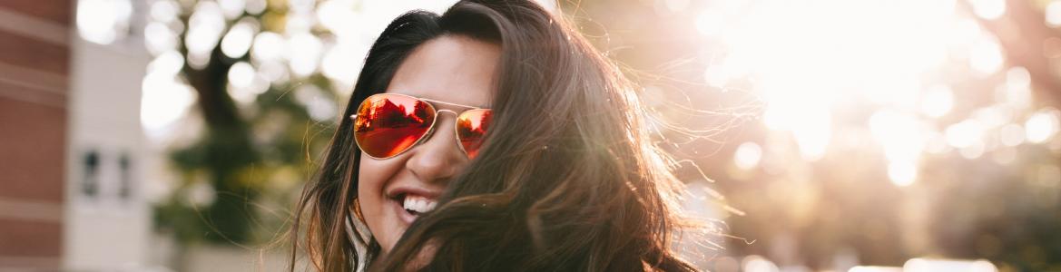 Chica con gafas de sol y pelo suelto sonriendo