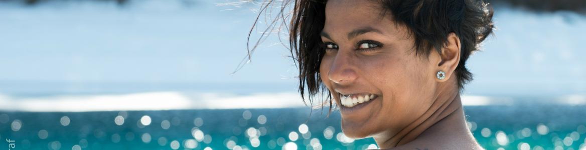 Chica sonriendo con mar al fondo