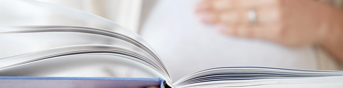 La mano de una persona sostiene un libro abierto