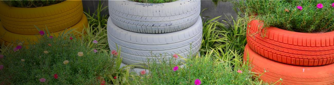 Fotografía de un jardín con ruedas de vehículos recicladas como maceteros
