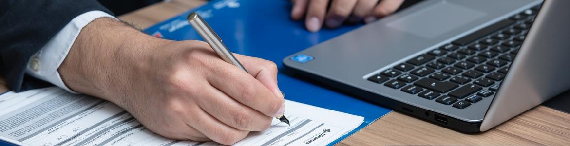 Cumplimentando impresos con portátil al costado