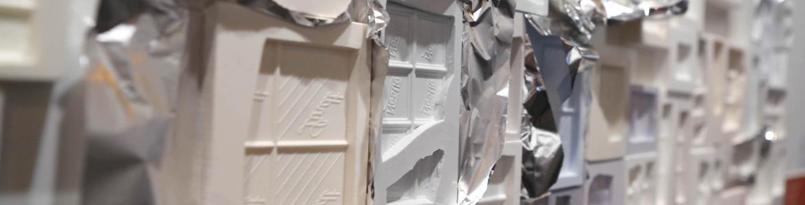Plates of molds of chocolates in different plastic materials and glued to each other like a panel in the wall