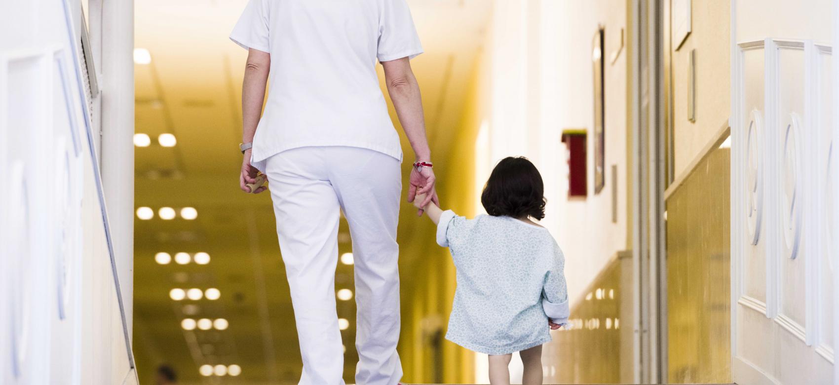 Enfermera dando la mano a una niña