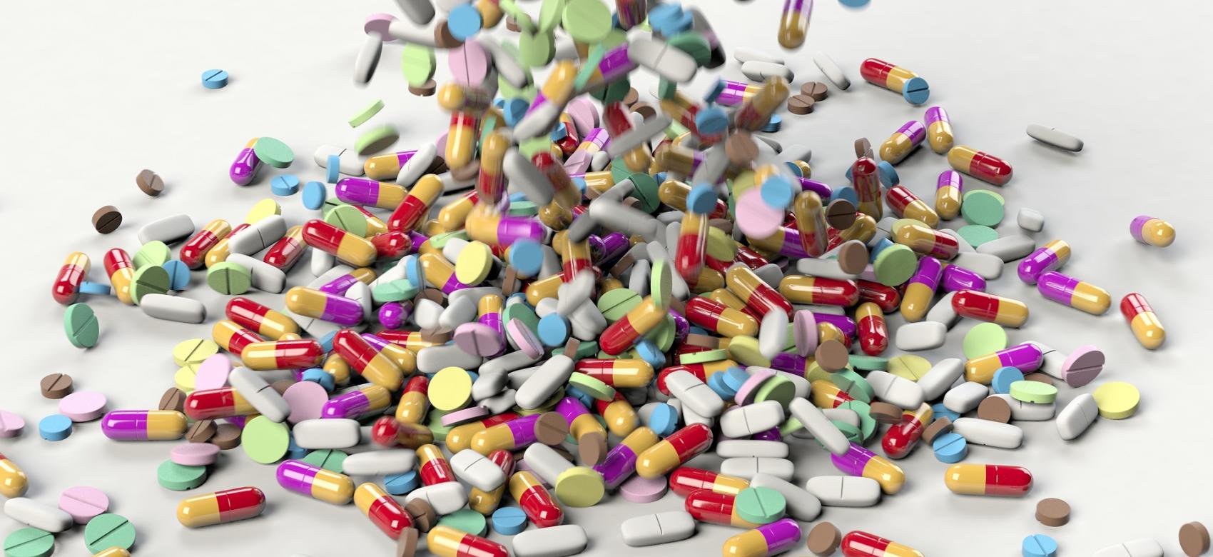 Multitud de cápsulas de medicamentos sobre una mesa