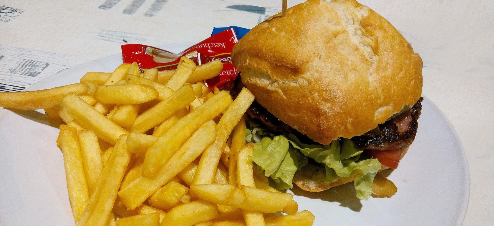 plato con hamburguesa, patatas fritas y ketchup