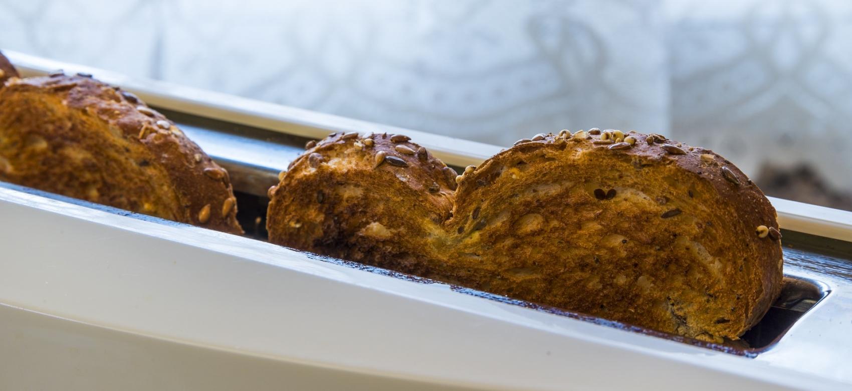 Tostador con rebanadas de pan de molde casi quemadas