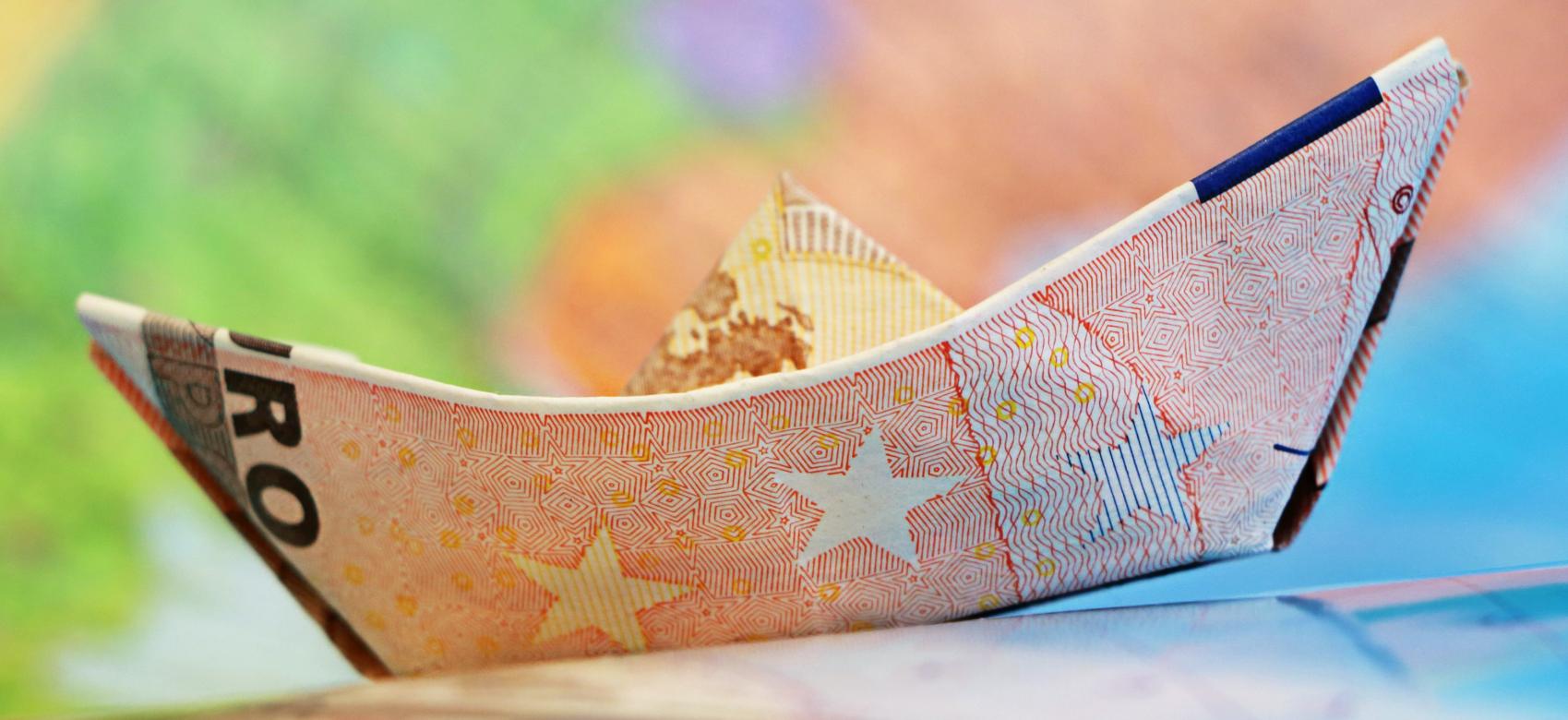 Subvenciones y ayudas Barco de papel con billete de euro