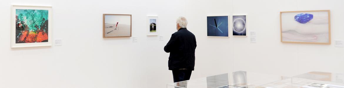 Hombre contemplando obras en una exposición