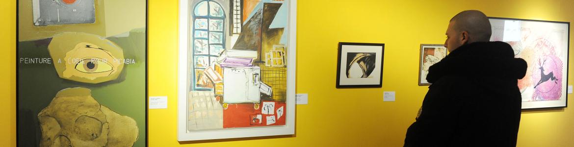 Visitante contemplando las obras en una exposición