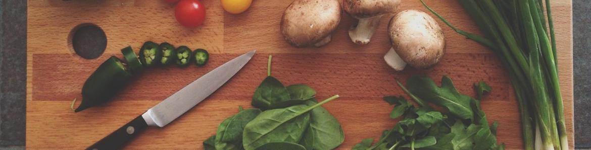 Tabla de cortar con un cuchillo y varios alimentos