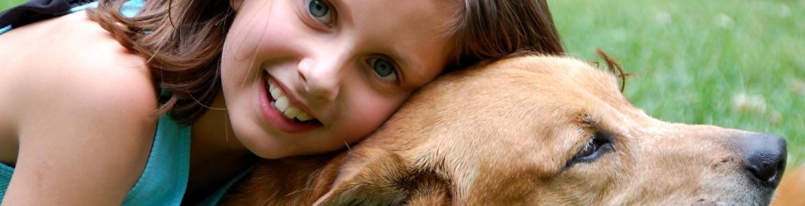 Niña abrazando a un perro en un parque